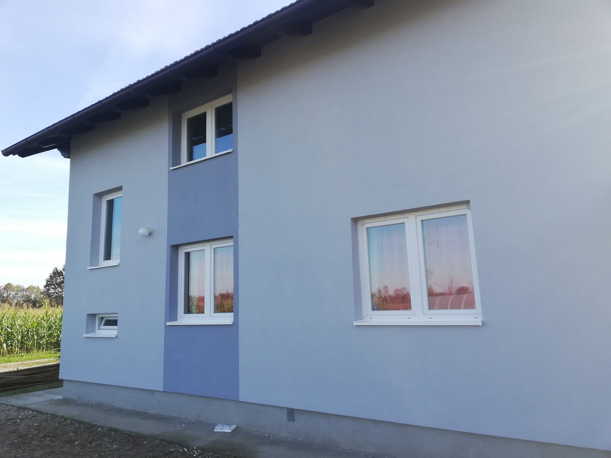 Bijeli PVC prozori s vanjskim klupicama na svježe okrečenoj fasadi
