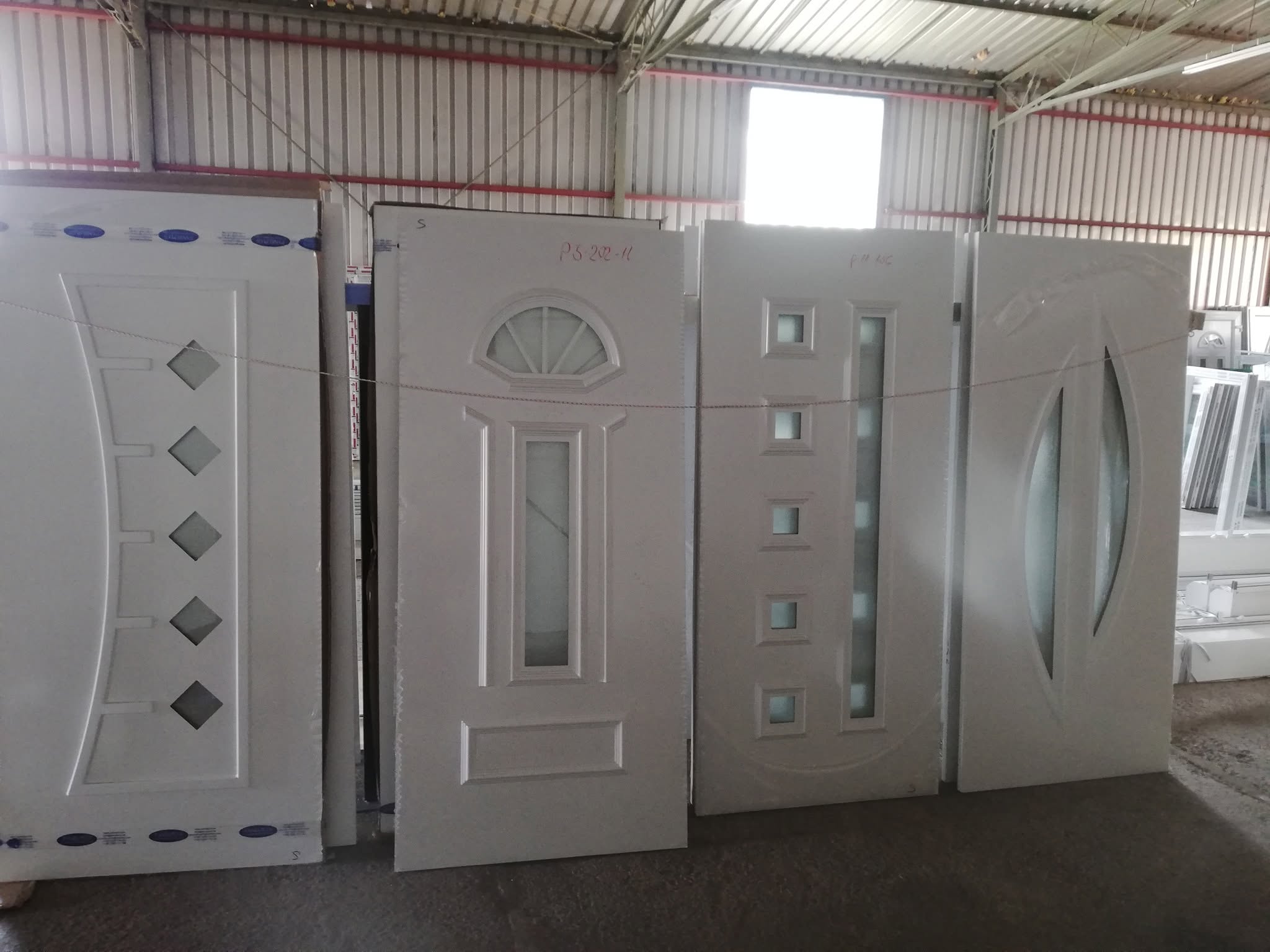 Krila PVC ulaznih vrata poredana u radionici